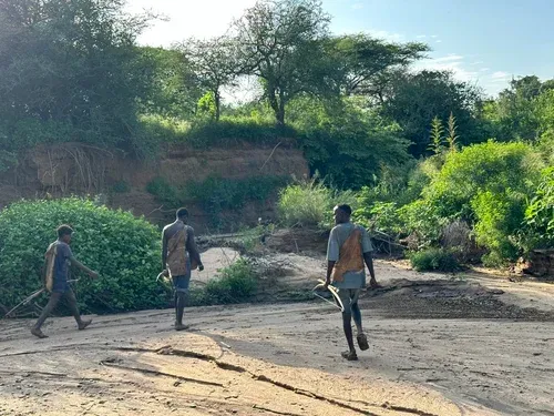 Hadzabe community members celebrating with song and dance around the fire near Lake Eyasi